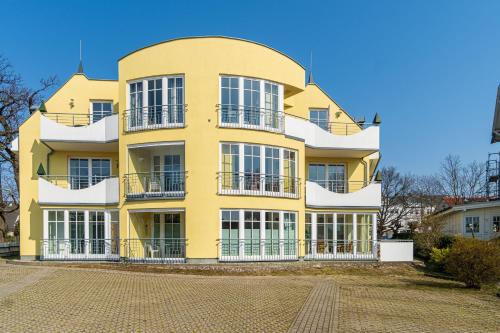 a yellow building with balconies on the side of it at Villa Vogelsang Ferienwohnung 2 "Kranich" in Binz