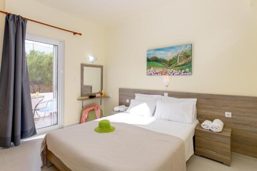 a bedroom with a bed and a window at Eden Beach Hotel in Agia Marina Nea Kydonias