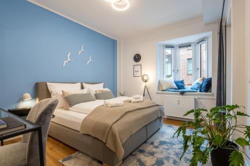 a bedroom with a bed with a blue wall at HYGGE: Design Apartment - 6 Personen - Zentral in Elmshorn