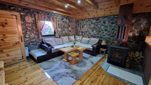 a living room with a couch and a wood stove at Stone Lodge 1 in Kolašin