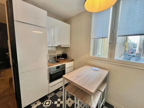 une petite cuisine avec une table et un réfrigérateur dans l'établissement Jaurès by Welcome to Cannes, à Cannes