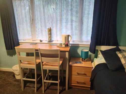 a bedroom with a desk and chairs next to a window at Cartmel in Aultbea