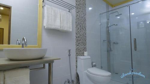 a bathroom with a shower and a toilet and a sink at Island Pavilion in Hangnaameedhoo