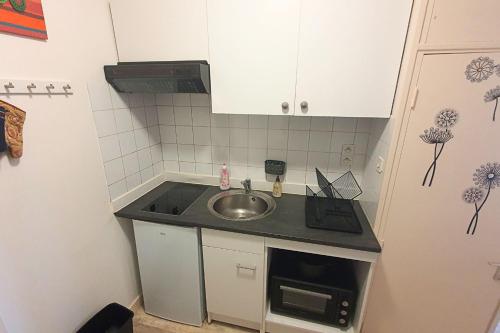 a small kitchen with a sink and a refrigerator at Very nice T3 at 3 min from the beach St Enogat in Dinard