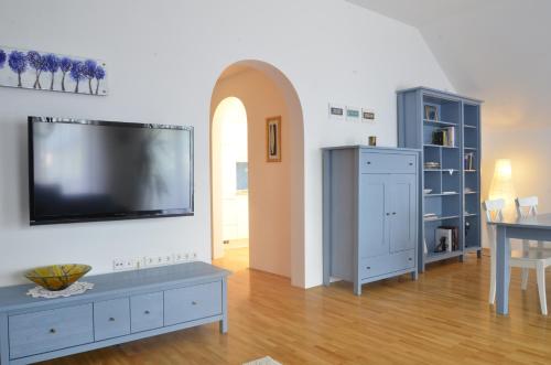 uma sala de estar com uma televisão de ecrã plano na parede em Apartment Galerija em Radovljica