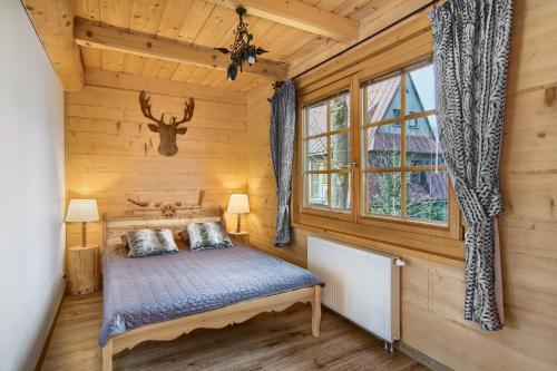 1 dormitorio con cama y cabeza de ciervo en la pared en Góralskie Bacówki z widokiem na Giewont, en Zakopane