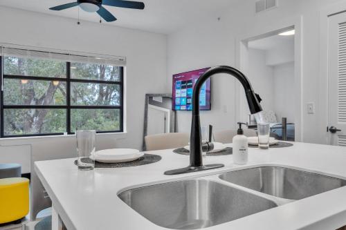 a white kitchen with a sink and a window at The Well 210 in Zephyrhills