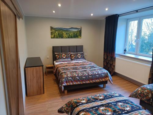 a bedroom with two beds and a window at Brenna Pogodny Dom in Górki Wielkie