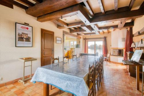 une grande salle à manger avec une table et des chaises dans l'établissement Moulin de charme - 5 personnes, à Saint-Sulpice
