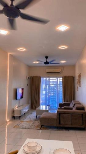 a living room with a couch and a ceiling fan at Rumah Aidin Homestay in Sitiawan