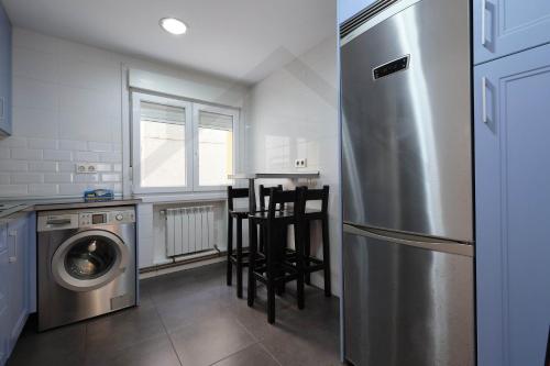 a kitchen with a refrigerator and a table and chairs at Piso Masip in Oviedo