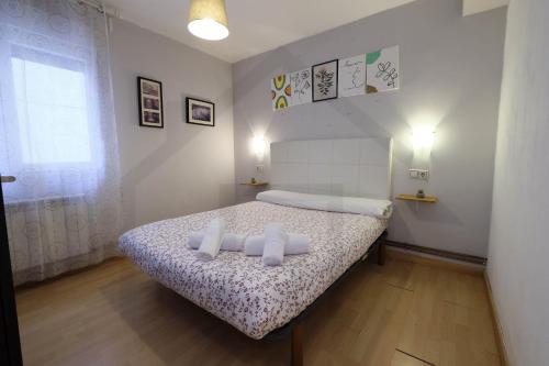 a bedroom with a bed with two pillows on it at Piso Masip in Oviedo