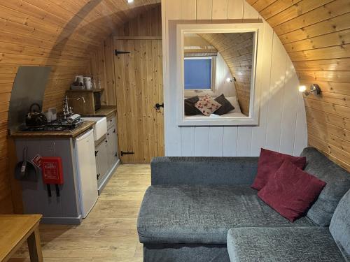 a living room with a couch in a tiny house at Mountain Edge Resort Mega pod 6 with Hot Tub in Church Stretton