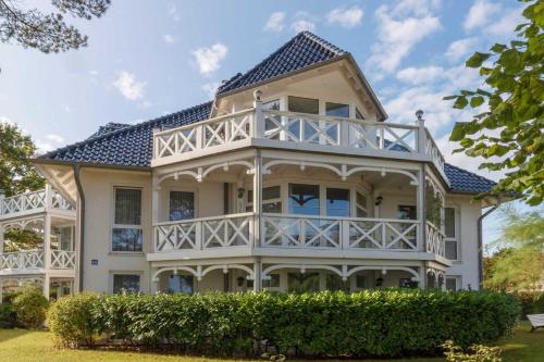 a large white house with a blue roof at Strelasund in Binz