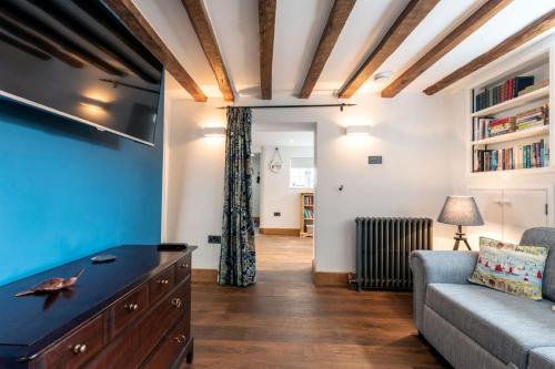 a living room with a couch and a tv at SandiComplex - 2 properties joined by a garden gate in Sandwich
