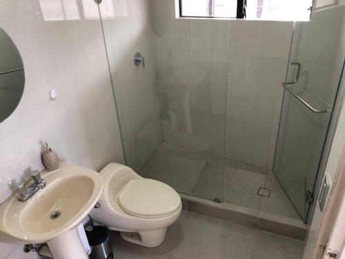 a bathroom with a shower and a toilet and a sink at Mirador del Estadio in Cuenca
