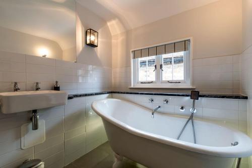 a bath tub and a sink in a bathroom at SandiComplex - 2 properties joined by a garden gate in Sandwich