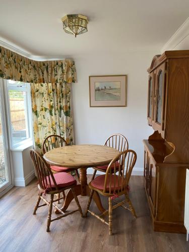 uma sala de jantar com uma mesa de madeira e cadeiras em Garden Cottage em Great Yarmouth