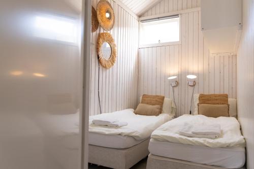 Habitación pequeña con 2 camas y espejo. en Willy Zuid en Katwijk aan Zee