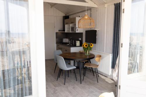a dining room with a table and chairs at Willy Zuid in Katwijk aan Zee