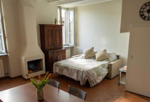1 dormitorio con 1 cama, chimenea y mesa en Casa vacanze Rasetto, en Costa di Mezzate