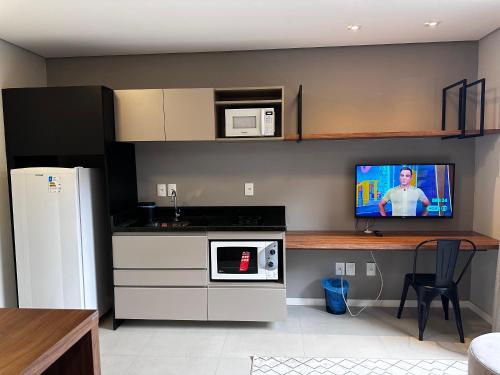 a kitchen with a counter and a tv on the wall at STUDIO Perto da feevale campus 2 in Novo Hamburgo