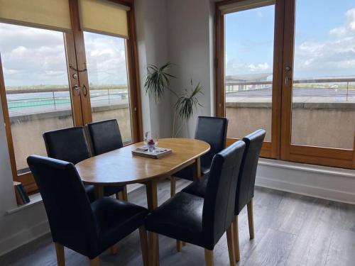 a dining room with a table and chairs and windows at Vera’s Penthouse in Wexford