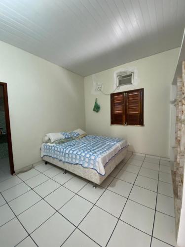 Casa Temporada في بارنايبا: غرفة نوم بسرير في غرفة بيضاء