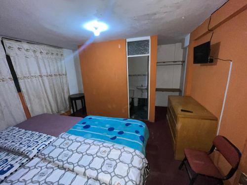 1 dormitorio con cama, escritorio y lavamanos en Villa el sol en Cajamarca