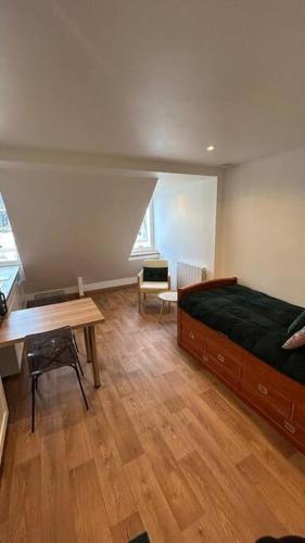 une chambre avec un lit, un bureau et une table dans l'établissement Le cocon, à Strasbourg