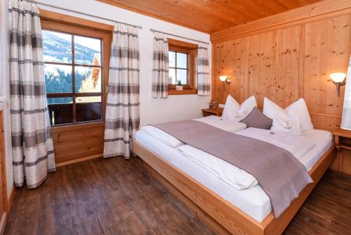 ein Schlafzimmer mit einem großen Bett in einem Holzzimmer in der Unterkunft Appartements Stoffenhof in Alpbach