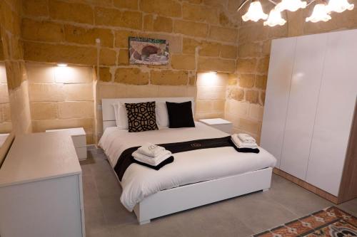 a bedroom with a bed with two towels on it at SurWig Vacation Townhouse in Kerċem