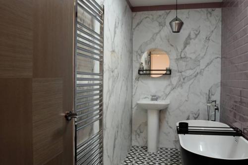 Un baño con lavabo, inodoro y espejo. en Stunning Coach House, en Largs