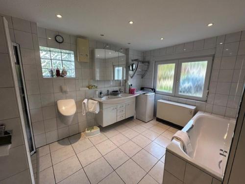 a bathroom with a tub and a sink and a bath tub at Ferienhaus Konze in Hilchenbach