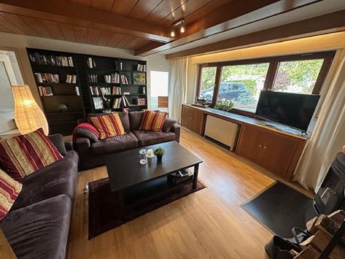 ein Wohnzimmer mit einem Sofa und einem TV in der Unterkunft Ferienhaus Konze in Hilchenbach