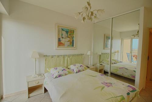une chambre avec un lit et un grand miroir dans l'établissement Appartement les Horizons sanguinaires Ajaccio, à Ajaccio