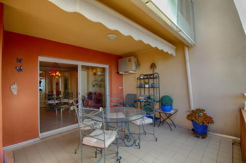 Cette chambre dispose d'une terrasse avec une table et des chaises. dans l'établissement Appartement les Horizons sanguinaires Ajaccio, à Ajaccio