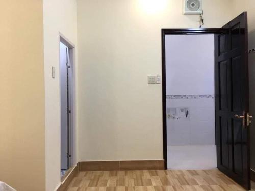 een deur in een kamer met een witte muur bij Nhà nghỉ Nam Anh in Can Tho