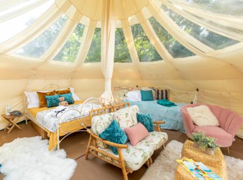 una habitación con 2 camas y sillas en una tienda de campaña en Andromeda 7 - Person Lotus Belle with 2 Tents, en Ross-on-Wye