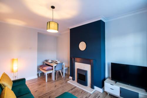 a living room with a fireplace and a table at Charming Middlesbrough Home in Middlesbrough