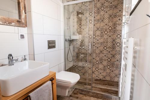 a bathroom with a toilet and a sink and a shower at HRYCÓWKA Domki z Widokiem in Grywałd
