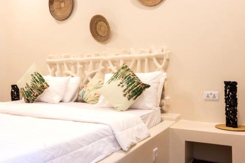 a bedroom with a white bed with pillows at RoRi Private Luxury Villas in Bwejuu