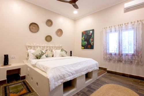 um quarto com uma cama branca e uma janela em RoRi Private Luxury Villas em Bwejuu