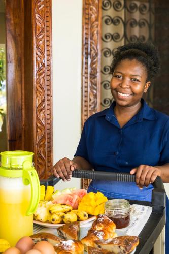 a woman holding a scale with a plate of food at RoRi Private Luxury Villas in Bwejuu