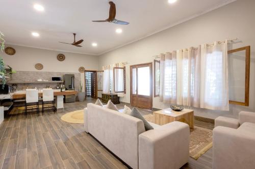 a living room with white couches and a kitchen at RoRi Private Luxury Villas in Bwejuu