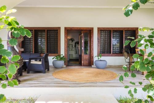 a front porch with a wooden floor and a door at RoRi Private Luxury Villas in Bwejuu