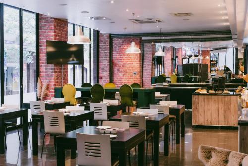 un restaurante con mesas y sillas y un bar en Cape Diamond Boutique Hotel, en Ciudad del Cabo