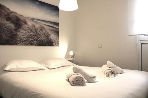 - une chambre avec un lit et des serviettes dans l'établissement Duplex vue Océan- Piscine-Plage à pied, à Anglet