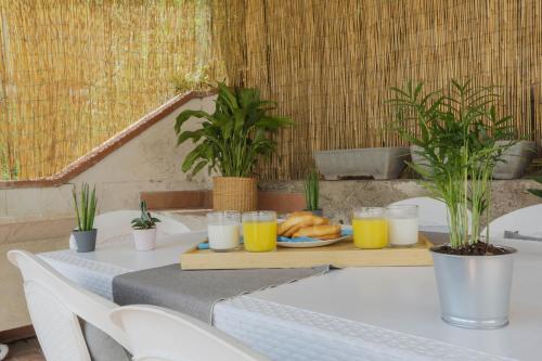 Una mesa con un plato de comida y vasos de jugo de naranja. en MaisonTuscany - Jacuzzi, en Carrara