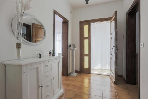 een badkamer met een spiegel en een witte kast bij Maison Tuscany Jacuzzi, Netlflix and Free Parking near Forte dei Marmi in Carrara